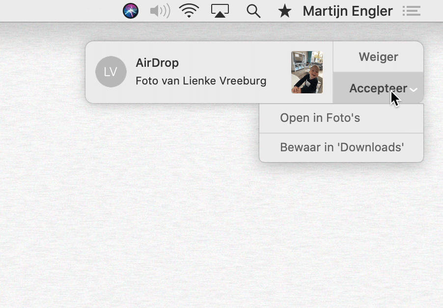 Twee keuzes in de AirDrop push notificatie: Open in Foto\'s, of Bewaar in Downloads